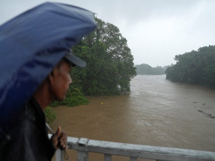 A man looks towards the swollen Kelani river, following heavy rainfall in Kelaniya